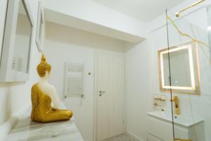 a statue of a woman sitting on a counter in a bathroom at GoldenLux Apartments in Oradea +14 photos