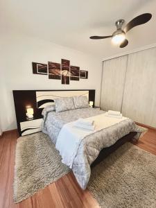 1 dormitorio con 1 cama y ventilador de techo en Apartamento Praia Naval, en A Illa de Arousa