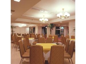 una sala conferenze con tavoli, sedie e lampadari a braccio di Ikaho Onsen Sanyo Hotel - Vacation STAY 26406v a Shibukawa