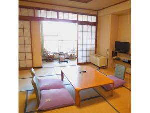 uma sala de estar com mesa e cadeiras em Ikaho Onsen Sanyo Hotel - Vacation STAY 26406v em Shibukawa