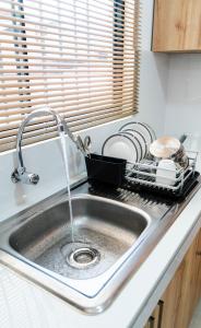 a kitchen sink with water coming out of a strainer at Casa La Merced in Tarapoto