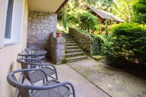 a patio with chairs and a table and stairs at Villa Harmónia Apartman in Visegrád