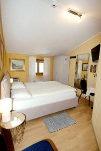 ein Schlafzimmer mit einem großen weißen Bett in einem Zimmer in der Unterkunft Al Battello in Morcote