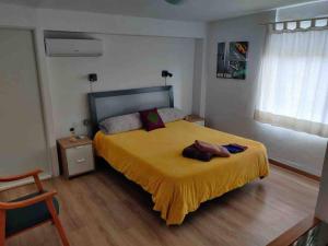 1 dormitorio con 1 cama grande con manta amarilla en Beautiful Centric Townhouse, en Denia