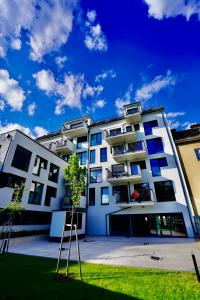 ein weißes Gebäude mit einem Baum davor in der Unterkunft DM & s Apartment in Wien