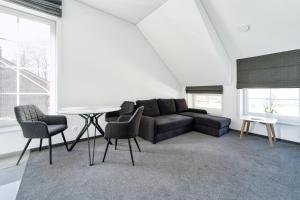 a living room with a couch and chairs and a table at Karklės Oazė in Karklė
