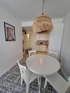 biała jadalnia z białym stołem i krzesłami w obiekcie Cozy apartment La Mata w mieście La Mata