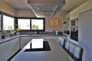 uma grande cozinha com uma mesa e cadeiras em Casa moderna a 300 metros de la playa. em Sant Josep de sa Talaia