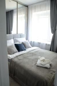 Un dormitorio con una cama grande con una toalla. en Tatyana-Hotel en Kostanái