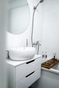 Baño blanco con lavabo y espejo en Tatyana-Hotel en Kostanái