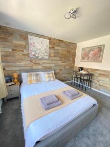 a bedroom with a large bed and a wooden wall at Gatwick Deluxe En-suite Rooms in Horley