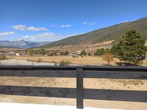 een hek met uitzicht op een veld en bergen bij Cabaña en Mesa de las Tablas, de fácil acceso y con excelentes vistas in Mesa de las Tablas