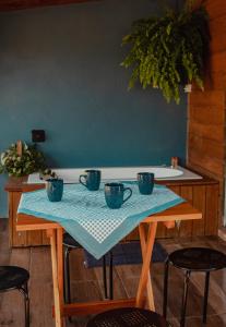 uma mesa com quatro copos azuis em cima em Recanto do Vale em Pomerode