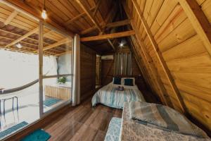 um quarto num chalé de madeira com uma cama e uma janela em Recanto do Vale em Pomerode