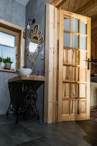 Łazienka z umywalką i drewnianymi drzwiami w obiekcie Obrochtowa Chata w mieście Kościelisko