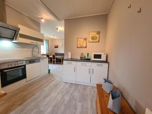 a kitchen with white cabinets and a counter top at Ferienwohnung mit Pool 2 in Nordleda