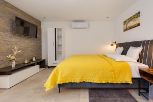 1 dormitorio con 1 cama con manta amarilla en Studio Apartment Carpe Diem, en Drinovci