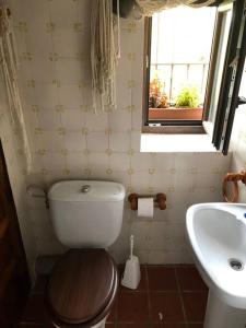 een badkamer met een toilet, een wastafel en een raam bij El Refugi in Vilafames