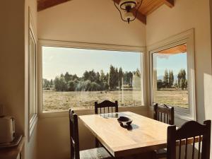 a dining room with a table and a large window at Casa de Campo La Chacra in San Carlos de Bariloche