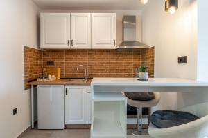eine Küche mit weißen Schränken und einer Arbeitsplatte in der Unterkunft Studio Apartment Carpe Diem in Drinovci