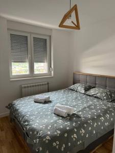 a bedroom with a bed with two towels on it at Flora apartment in Lukavica