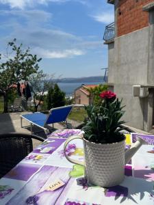 a table with a vase with a flower on it at Rooms Verda in Senj