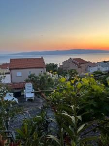 a white chair sitting in a yard with a house at Rooms Verda in Senj