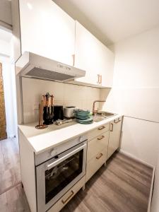 een keuken met witte kasten en een fornuis met oven bij Apartment für 3 Gäste mit kostenlosen Parkplätzen und Lift in Hannover