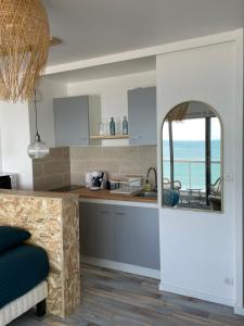 - une cuisine avec un miroir offrant une vue sur l'océan dans l'établissement Face Mer vue d'exception Studio rénové au 9ème étage, à Les Sables-dʼOlonne