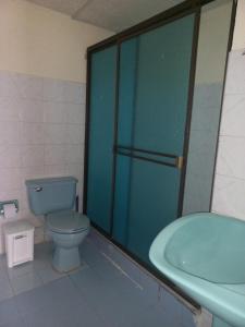 a bathroom with a blue toilet and a tub at Victoria brand 2 in Bogotá
