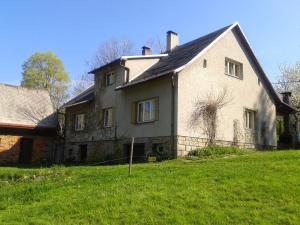 ein großes weißes Haus auf einem grünen Feld in der Unterkunft Chalupa Maruška in Čeladná