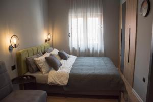a bedroom with a bed with pillows and a window at Old Town Premium Apartments in Mostar