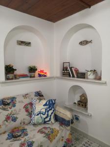 un soggiorno con divano e scaffali sul muro di Al Limone a Città di Lipari
