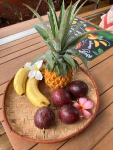 una cesta de fruta con piña y plátanos en KazaCoco Bungalow à 5 min à pieds du lagon en La Saline les Bains