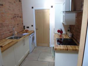 a small kitchen with a sink and a stove at The Retreat in York +5 photos