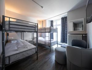 a bedroom with two bunk beds and a chair at Hotel Bristol in Luxembourg