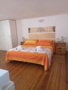 una camera da letto con un grande letto con una coperta arancione di Al Limone a Città di Lipari