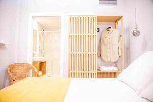 um quarto com um armário com um casaco branco numa prateleira em O Legado de Ramira em Vilanova de Arousa
