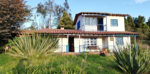 une maison blanche avec un toit rouge dans l'établissement Hermoso Refugio en la Laguna de Suesca, à Suesca