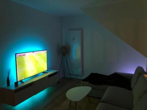 a living room with a television with a blue light at Wolu Room in Brussels