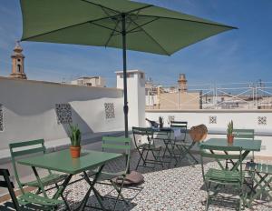 d'une terrasse avec des tables, des chaises et un parasol. dans l'établissement NEREA - Apulian Suite and Rooms, à Monopoli