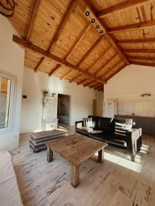 a living room with a wooden table and a couch at Casa de Campo La Chacra in San Carlos de Bariloche