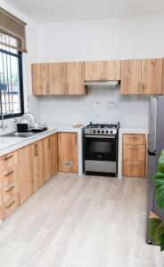 uma cozinha com armários de madeira e um fogão em Casa La Merced em Tarapoto