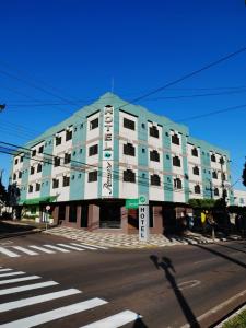 ein großes blaues Gebäude in einer Stadtstraße mit einem Fußweg in der Unterkunft ROMA'S HOTEL in Umuarama