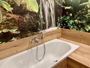 a bath tub in a bathroom with a waterfall at NEU 2023: Ferienwohnung THEO in Leinefelde