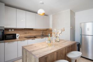 a kitchen with white cabinets and a wooden counter top at Holiday Home Franika in Medulin
