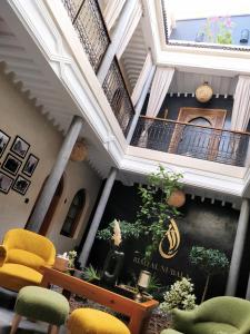 a room with a staircase with yellow and green chairs at Riad Al Nubala in Marrakesh