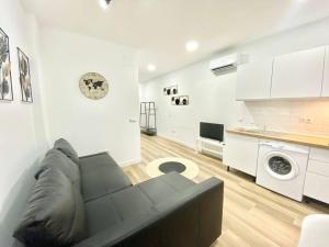 salon z czarną kanapą i kuchnią w obiekcie Madrid Rio Amparo Usera w Madrycie +20 zdjęć