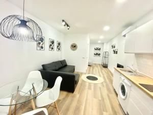 salon z czarną kanapą i stołem w obiekcie Madrid Rio Amparo Usera w Madrycie