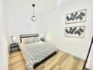 1 dormitorio con 1 cama con edredón blanco y negro en Madrid Rio Amparo Usera, en Madrid